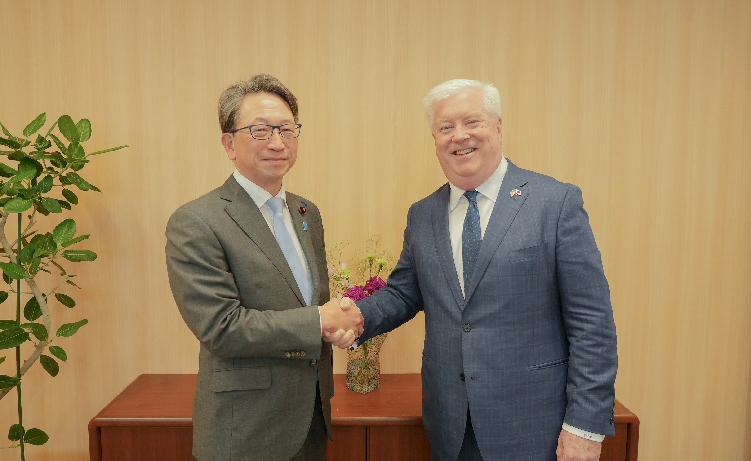 2人が笑顔で握手を交わしている