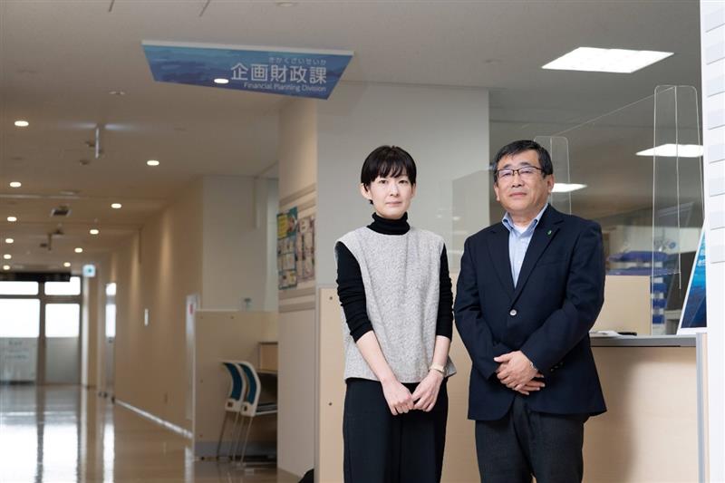 市役所の窓口前に男女2名が横並びに並んでいる写真
