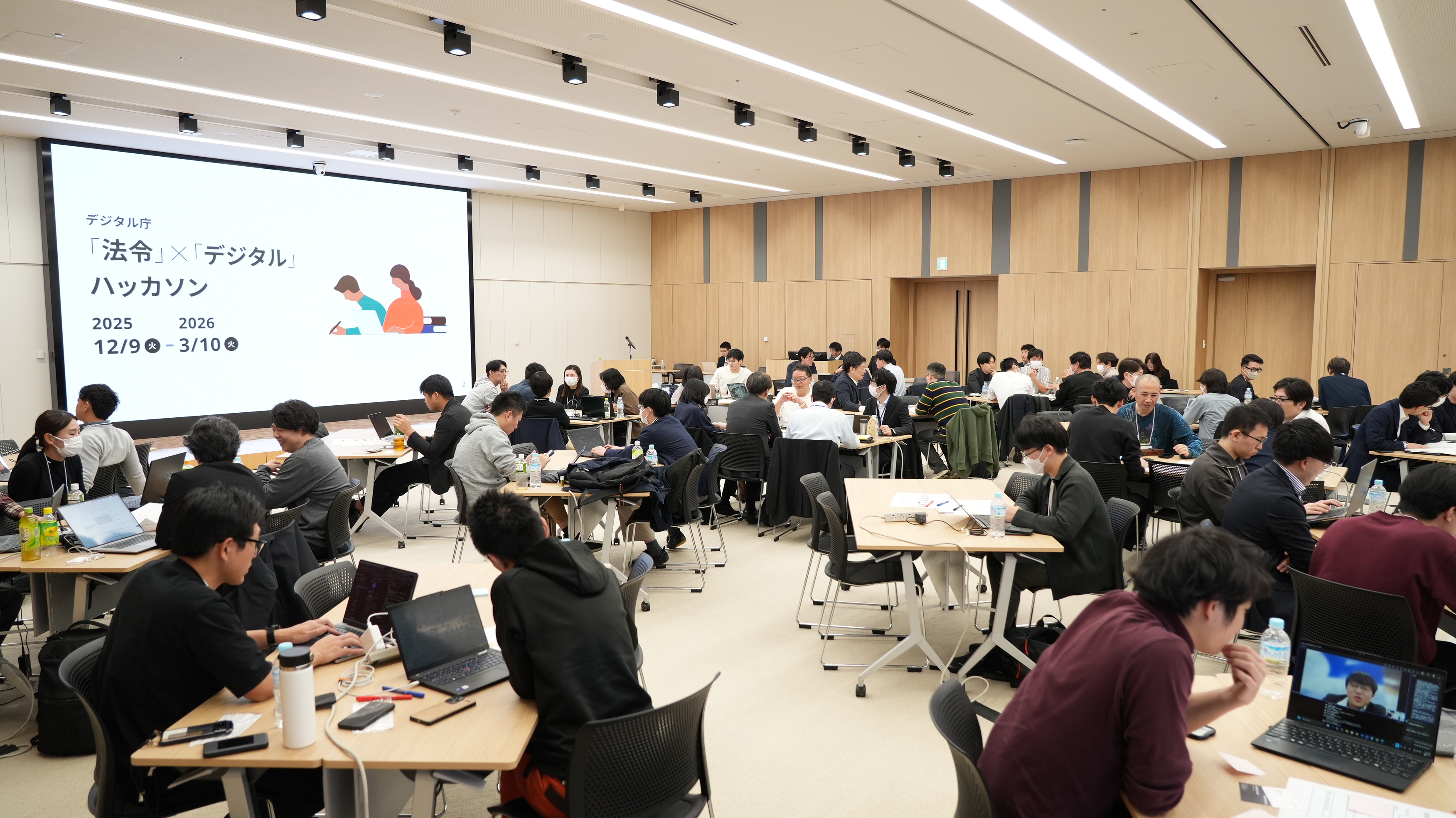 A view of the entire interior of the hackathon venue, with teams at the table discussing their ideas for the product to be developed. 