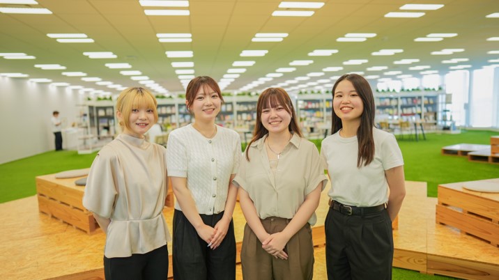 女性4人が横一列に並んで立っている写真。全員が笑顔で前を向いている。