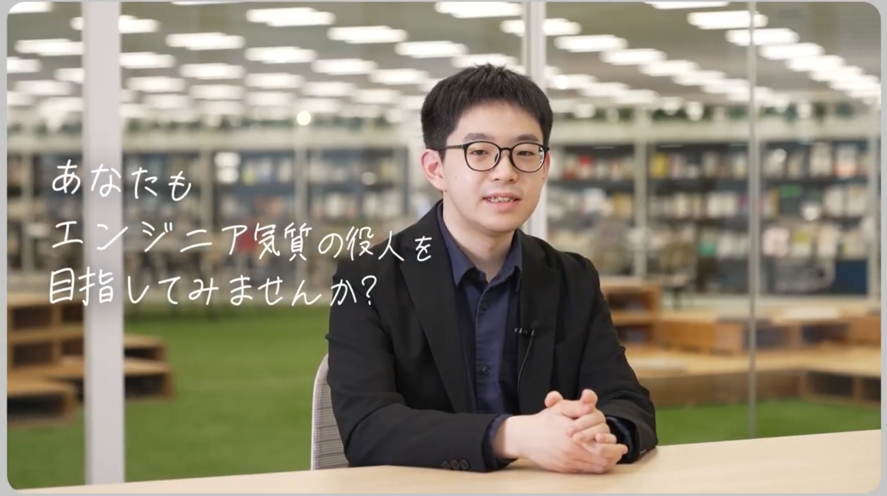 本棚と明るい照明のあるモダンなオフィス空間でテーブルに座る人物の写真。左側に白い文字で「あなたもエンジニア気質の役人を目指してみませんか？」と記載されている