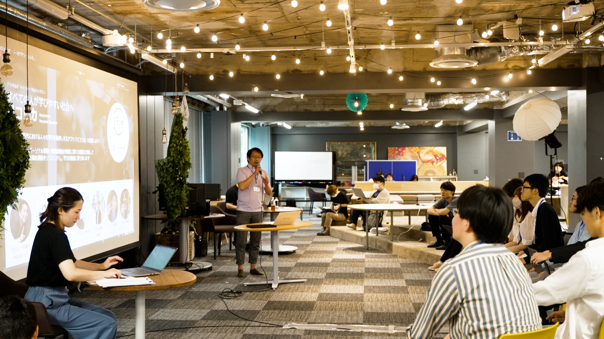 A scene from a hackathon event. A presentation being made.