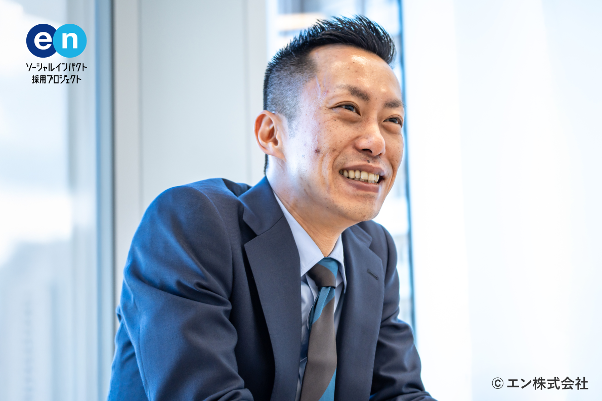 A photo showing a male employee. The logo of "en Social Impact Recruitment Project" is on the upper left, suggesting recruitment and social contribution activities. 