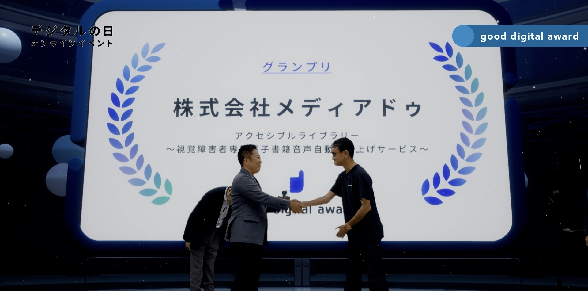 A representative of Media Do Co., Ltd., who won the good digital award 2022 Grand Prix, is being honored. In the center of the screen, the representative and the Minister Kono are facing each other and shaking hands.