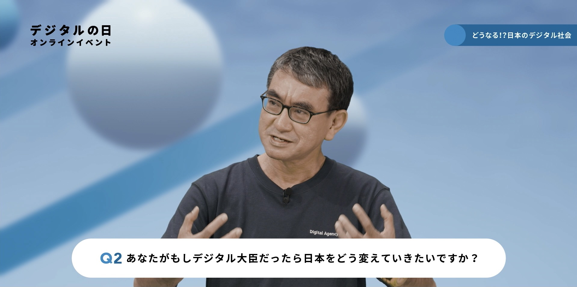 「どうなる！？日本のデジタル社会」イベントに参加する河野大臣の写真。写真の下にテロップで「Q2 あなたがもしデジタル大臣だったら日本をどう変えていきたいですか？」と質問が表示されている。