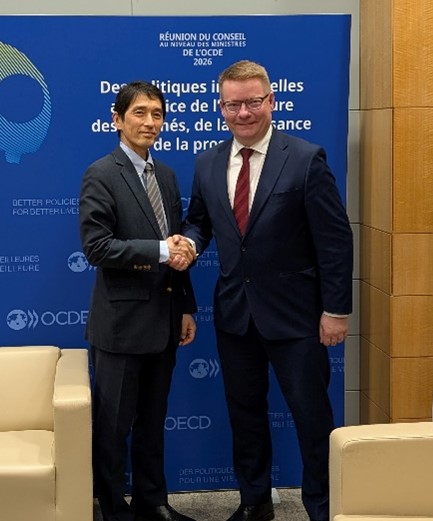 A photo of Vice-Minister Misumi and Permanent Secretary Jaatinen of Ministry of Economic Affairs and Employment, Finland  standing side by side and shaking hands.