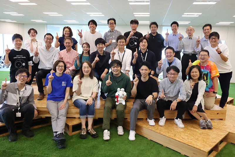 3列に並び26名が笑顔で写っている写真。人差し指を立てたポーズでワンチームを表している