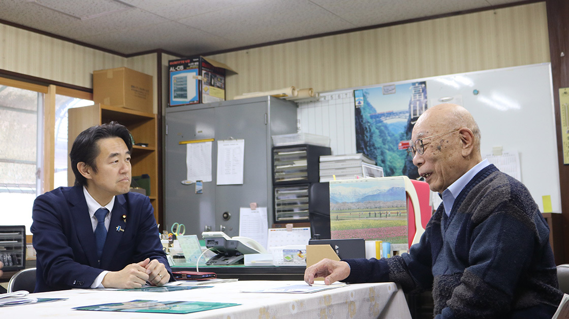 黒東自動車商会事務所にて、穂坂デジタル副大臣が近江代表取締役と座りながら意見交換している様子