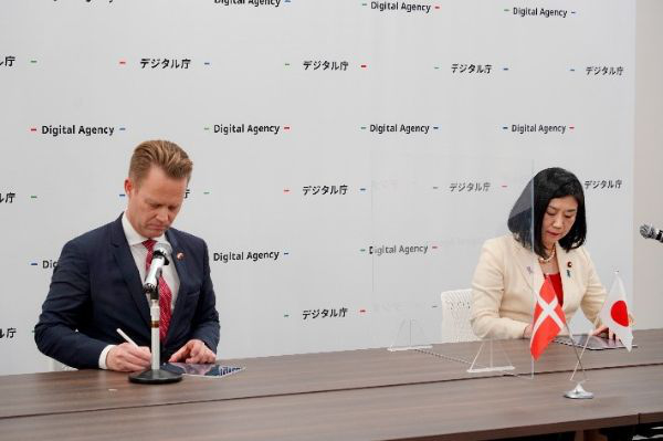 Photo of 2 people. MAKISHIMA Karen, then Minister for Digital and Jeppe KOFOD, Minister for Foreign Affairs of the Kingdom of Denmark signing the Memorandum of Understanding displayed on the tablet devices.