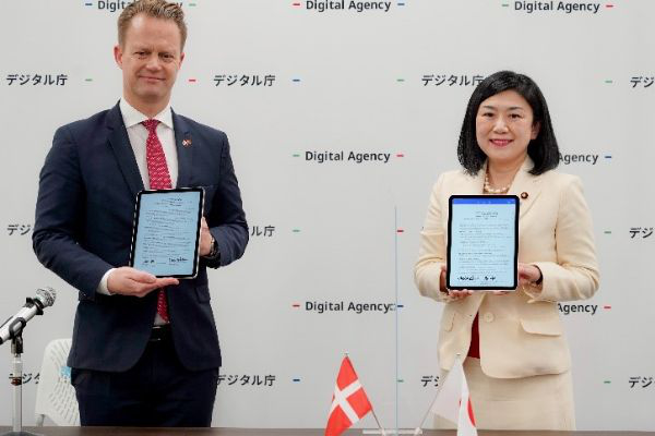 Photo of 2 people. MAKISHIMA Karen, then Minister for Digital and Jeppe KOFOD, Minister for Foreign Affairs of the Kingdom of Denmark signing the Memorandum of Understanding displayed on the tablet devices.