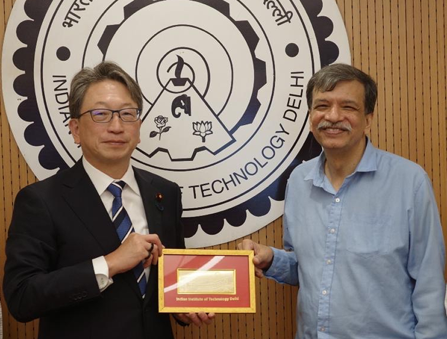 左に平デジタル大臣、右にインド工科大学デリー校のバナジー学長が立ち、額入りのプレートを二人で持っている写真。背景には同大学のロゴパネルがある。