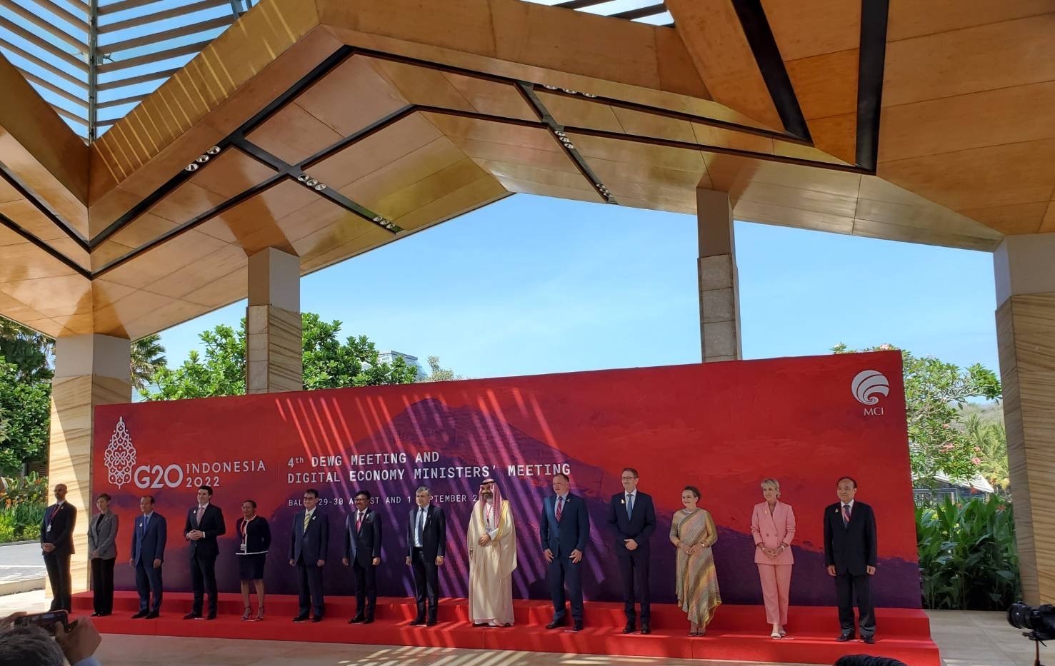 G20デジタル経済大臣会合への出席者が赤色の壇上に一列に並んでいる。