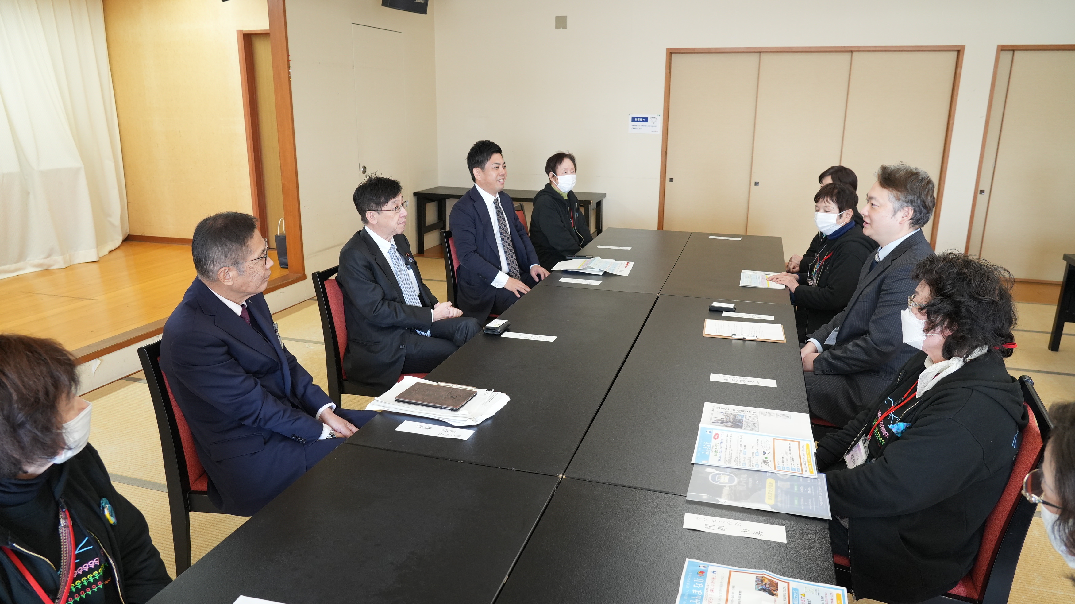 松本デジタル大臣と複数名の人々が、大テーブルを囲んで座りながら意見交換会をする様子。