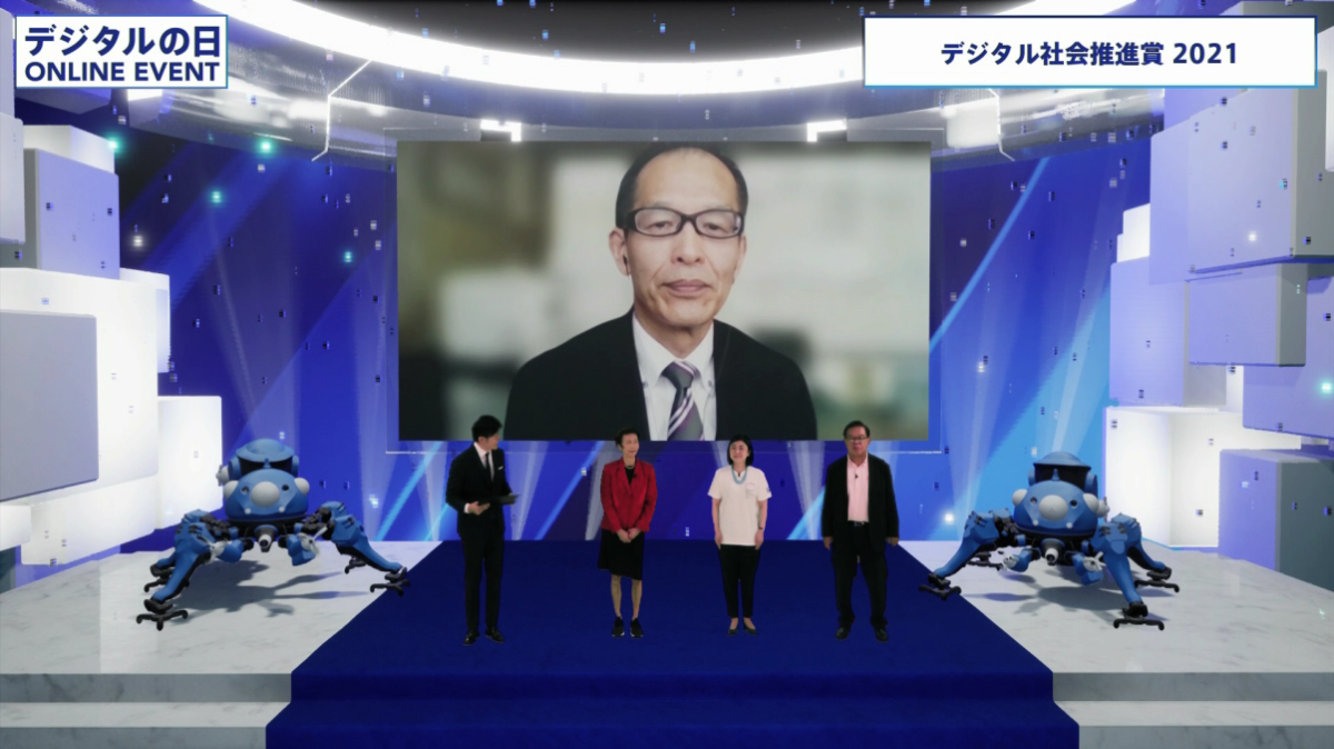 A photo showing the presentation of the digital society Promotion Award 2021. From the left, Chief Officer of the Digital Agency Yoko Ishikura, Minister Makishima, and Jun Murai are standing side by side.