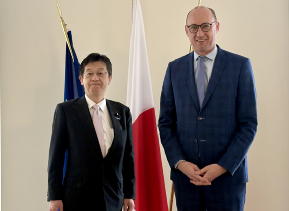 松本デジタル大臣とヴィンセント・ヴァン・ペテヒェム副首相兼予算・行政簡素化担当大臣が国旗の前に並び正面を向いている写真。