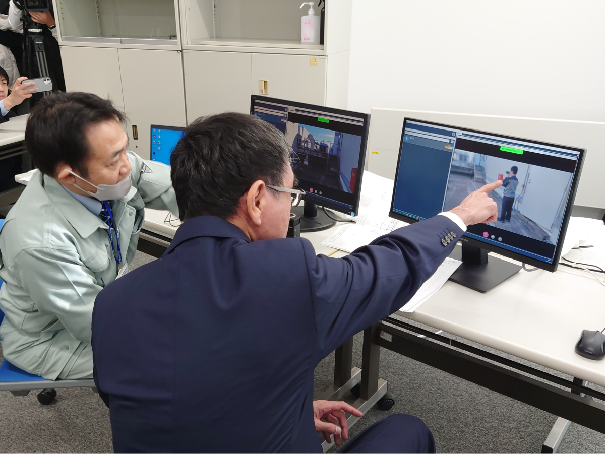 A Minister Kono who receives an explanation about demonstration experiments while looking at a PC monitor