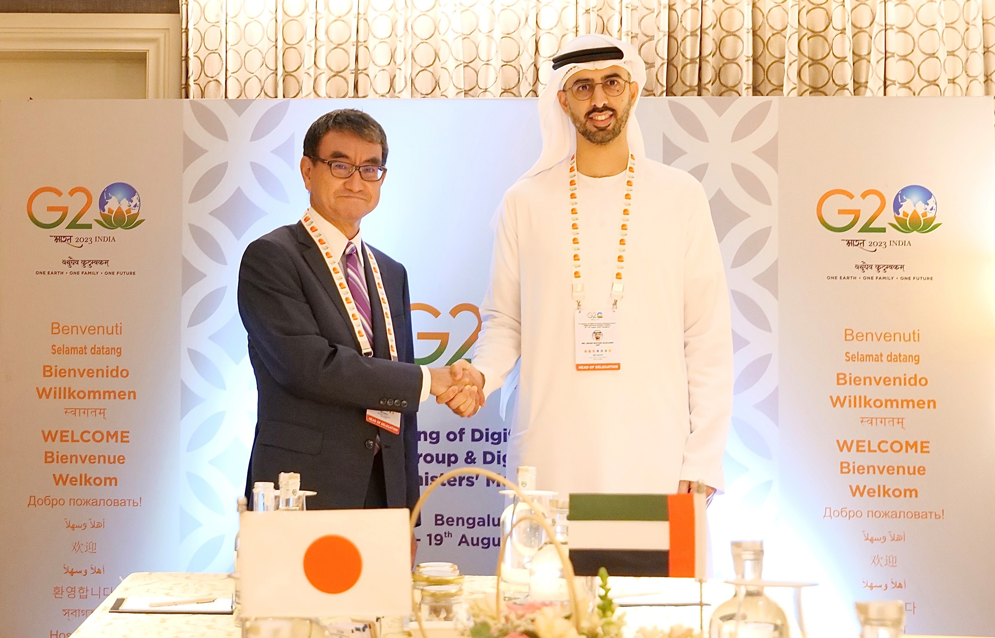 Photo of Minister Olama of UAE (right) and Minister Kono (left) shaking hands.