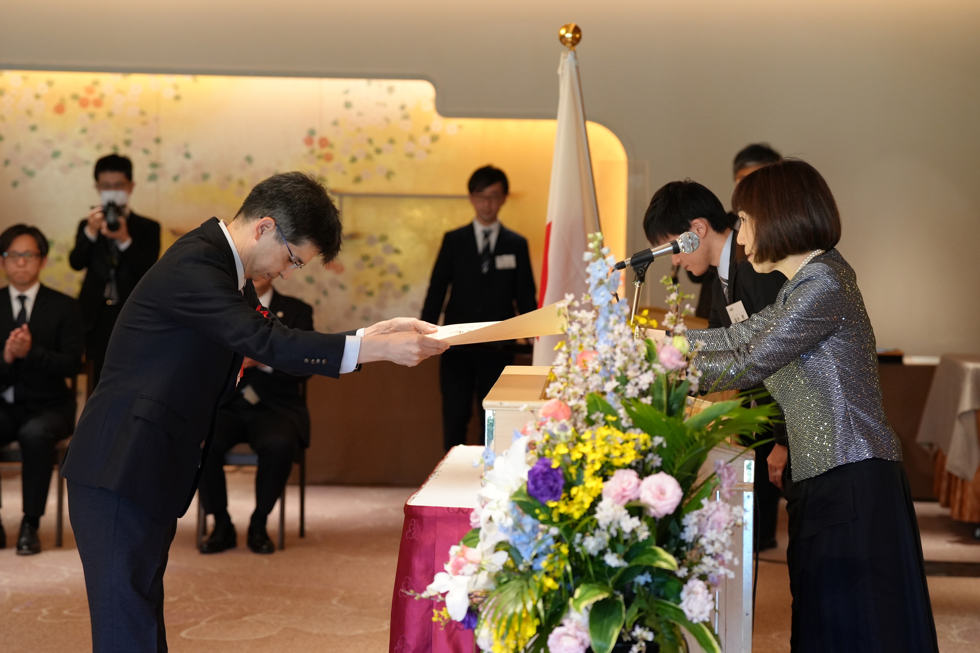 明治記念館にて授与式を行っている風景。デジタル統括官が川本裕子総裁(人事院)より賞状を受け取っている。