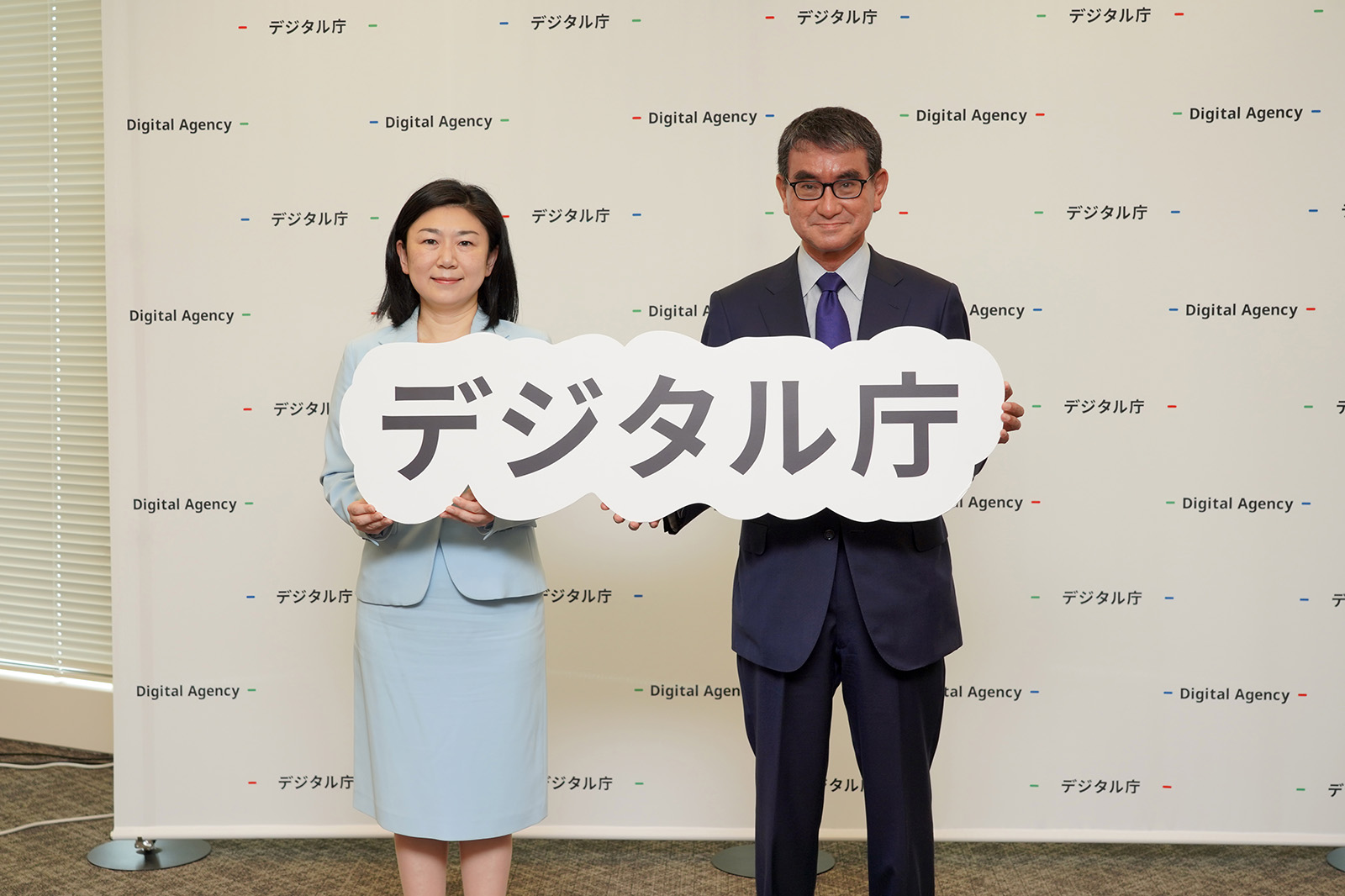 Two shots of former Minister for Digital Transformation MAKISHIMA Karen and new Minister for Digital Transformation KONO Taro, both holding the Digital Agency logo.