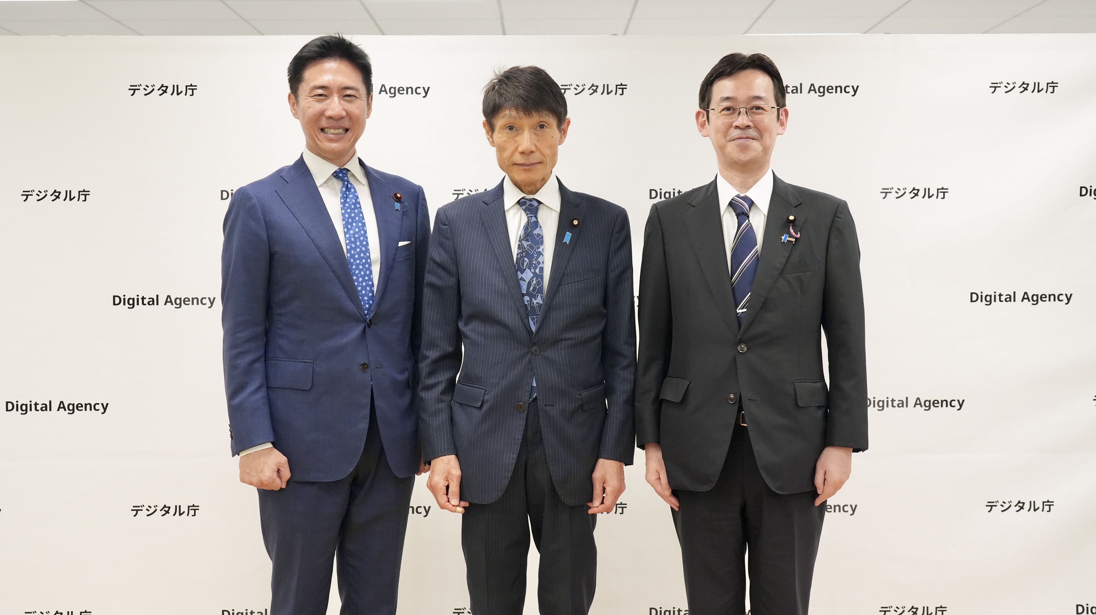 政務三役がデジタル庁のパネルを持ち笑顔で記念撮影する様子。