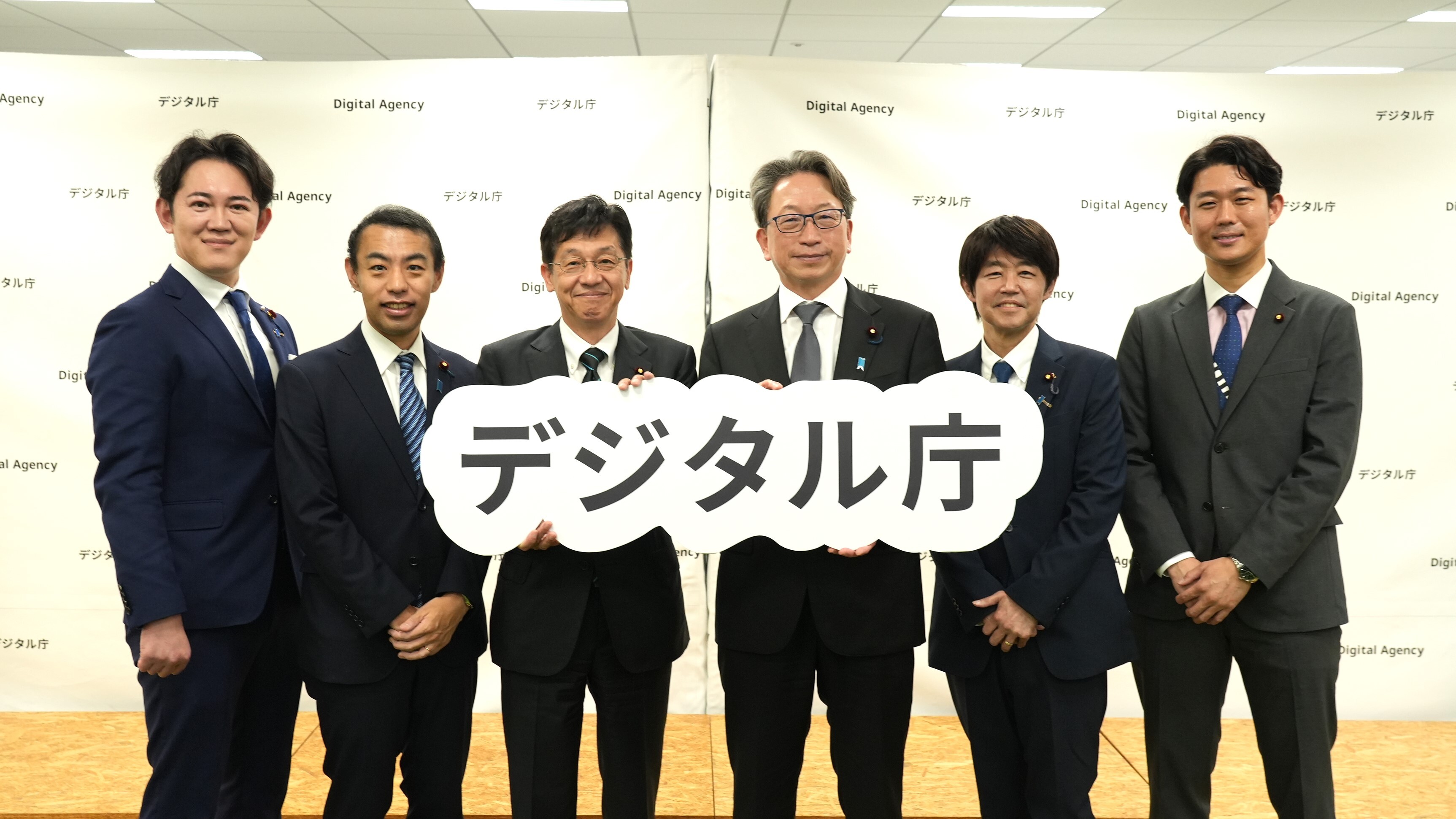デジタル庁のパネルを持ち記念撮影する、平前大臣、穂坂前副大臣、岸前大臣政務官、松本大臣、今枝副大臣、川崎大臣政務官