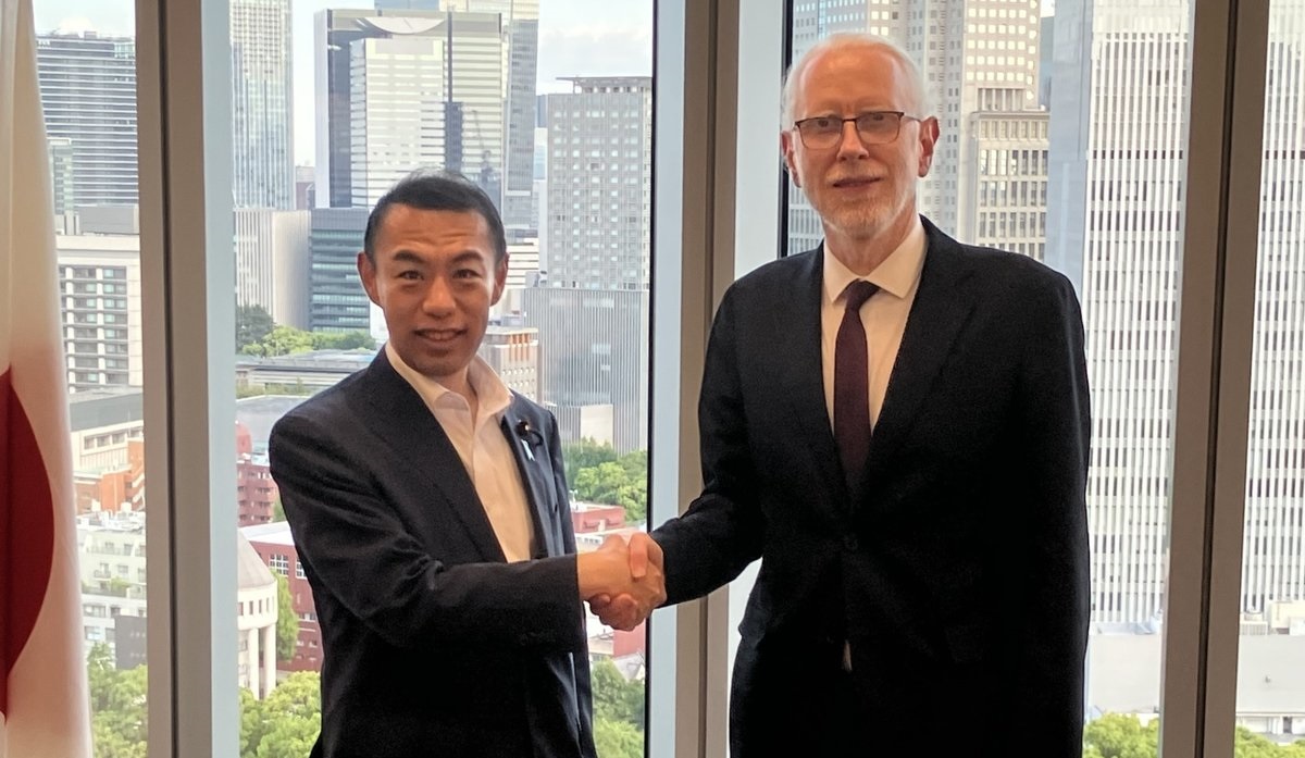 今枝副大臣（左）とコソボのヤグジウ デジタル化・公共行政大臣（右）が会談中に笑顔で握手している様子。