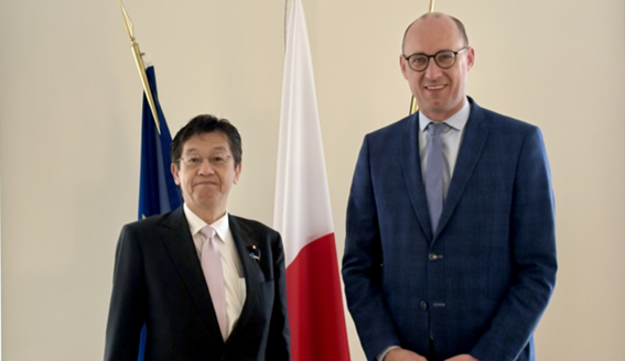 松本デジタル大臣とヴィンセント・ヴァン・ペテヒェム副首相 兼 予算・行政簡素化大臣が国旗の前に並び正面を向いている。