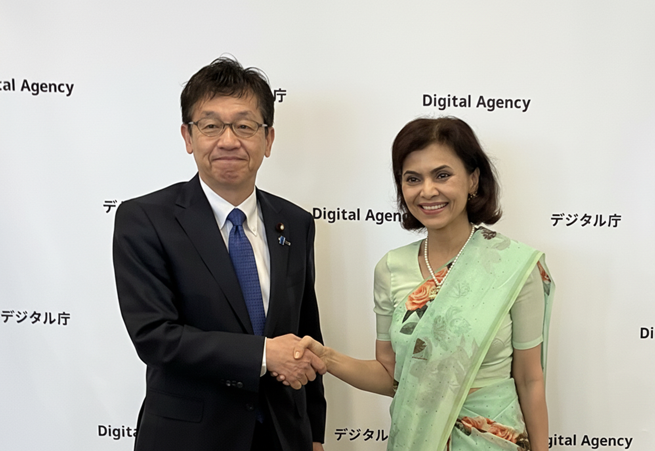 松本デジタル大臣とマリック駐日インド大使の写真。左に松本デジタル大臣、右にマリック駐日インド大使が立っており、二人が笑顔で握手をしている。